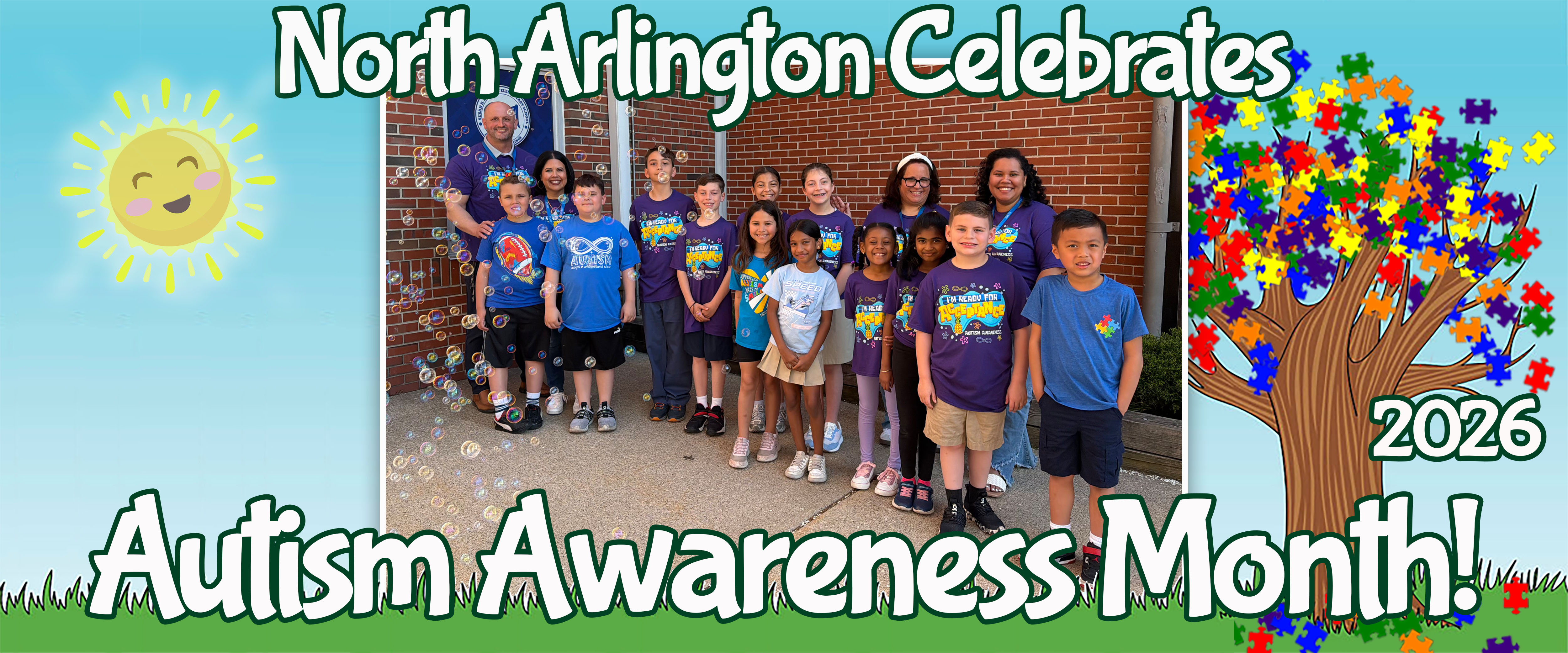 A group of children and adults stand in front of a brick building with a smiling sun and a puzzle-piece tree in the background.
