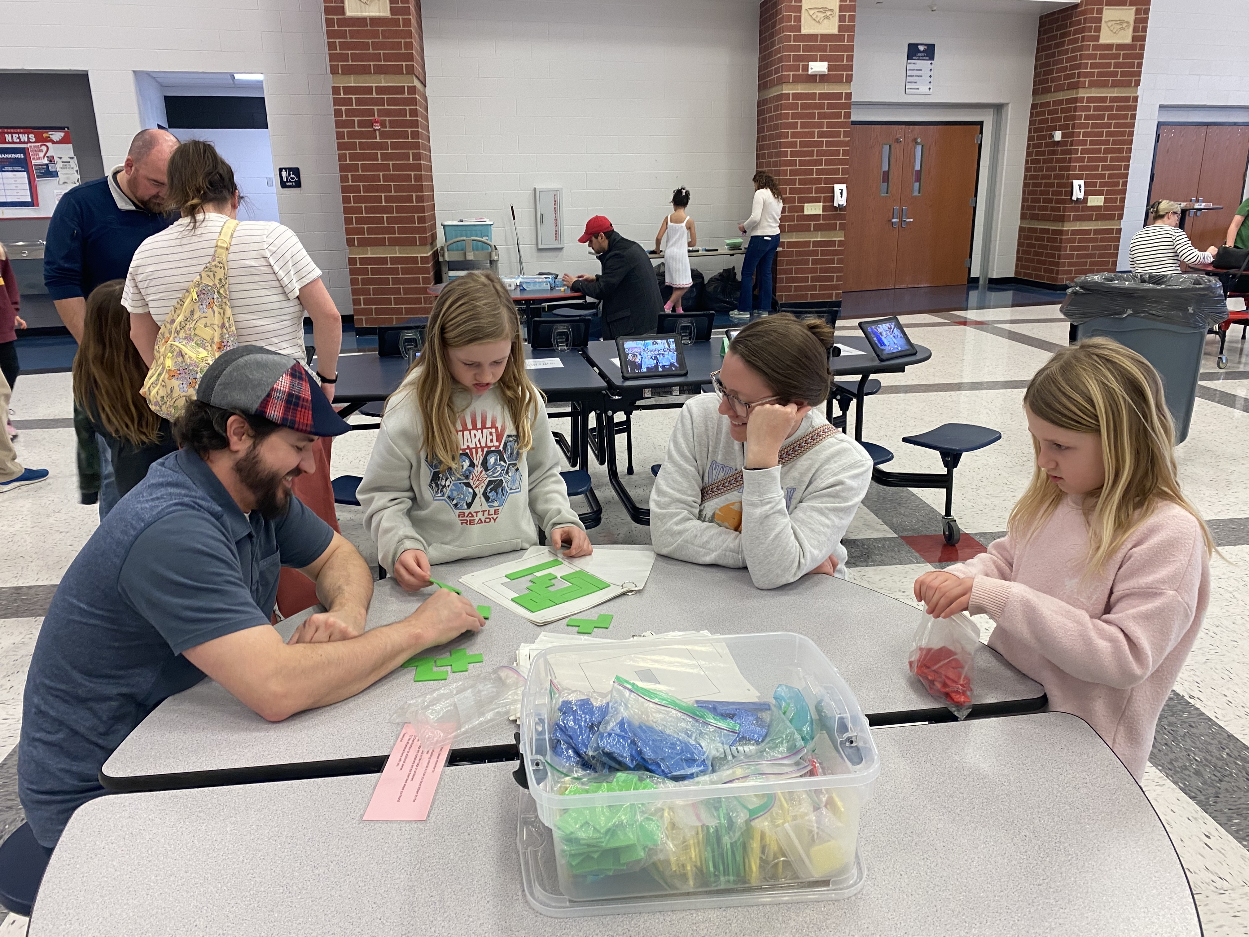 Student teaching their family how to play a board game at Horizons Family Game Night