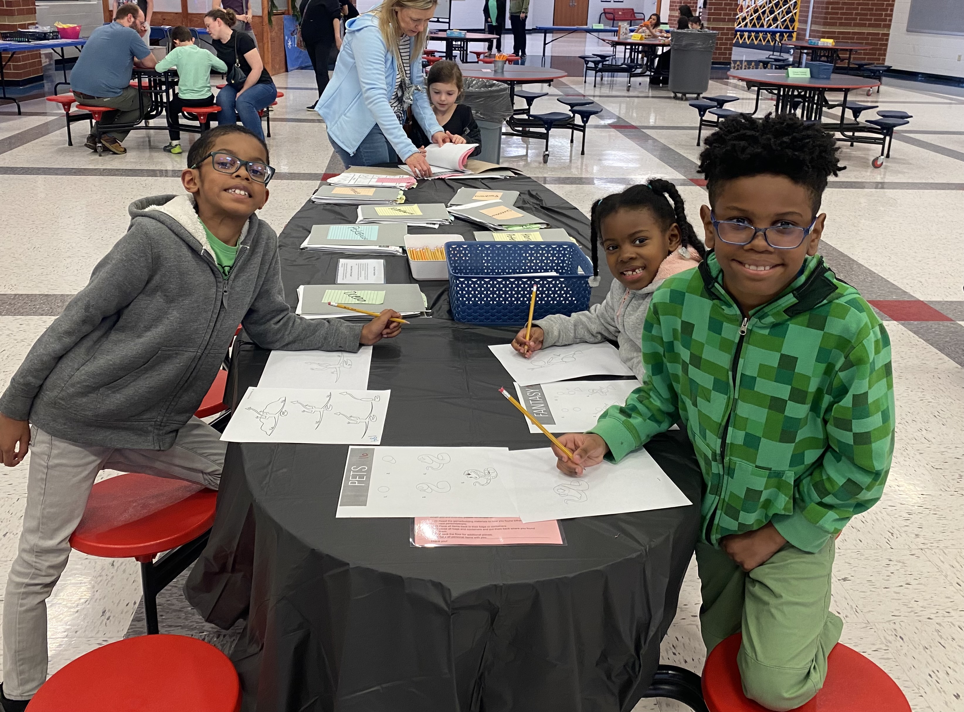 Family showing off their drawing skills at the Horizons Family Game Night