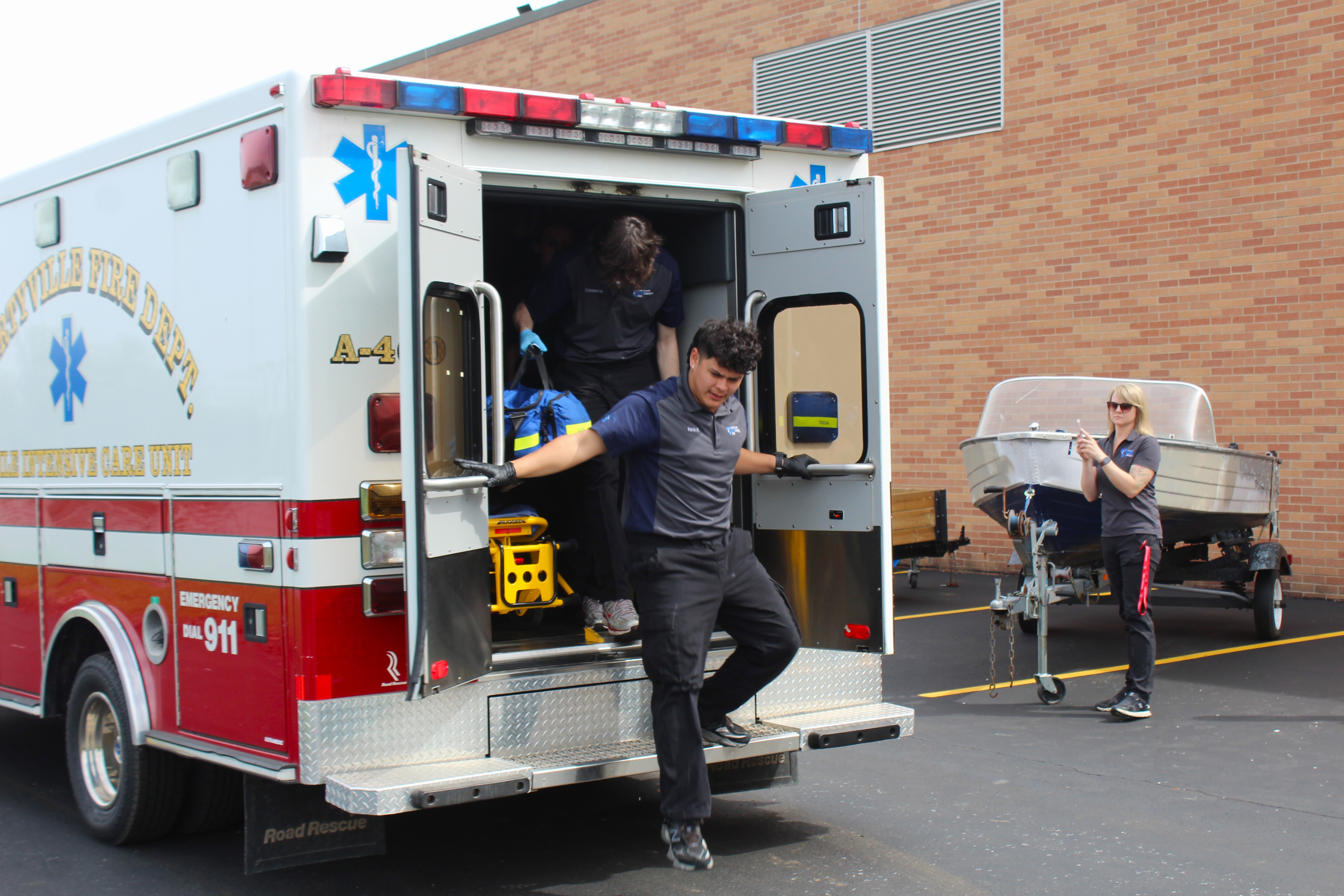 An EMS student is exiting the ambulance