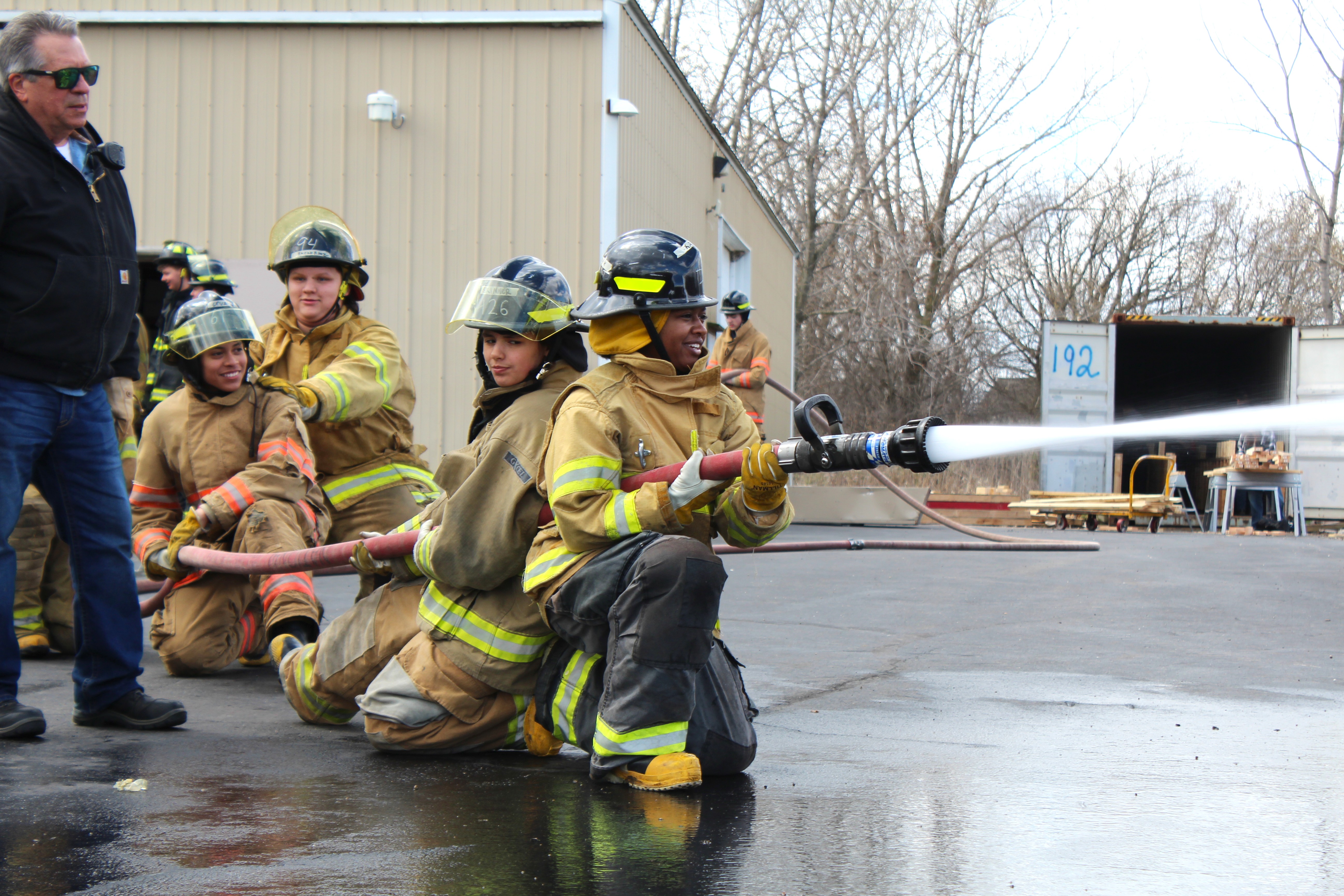 a firefighting student is aiming the hose toward the distance