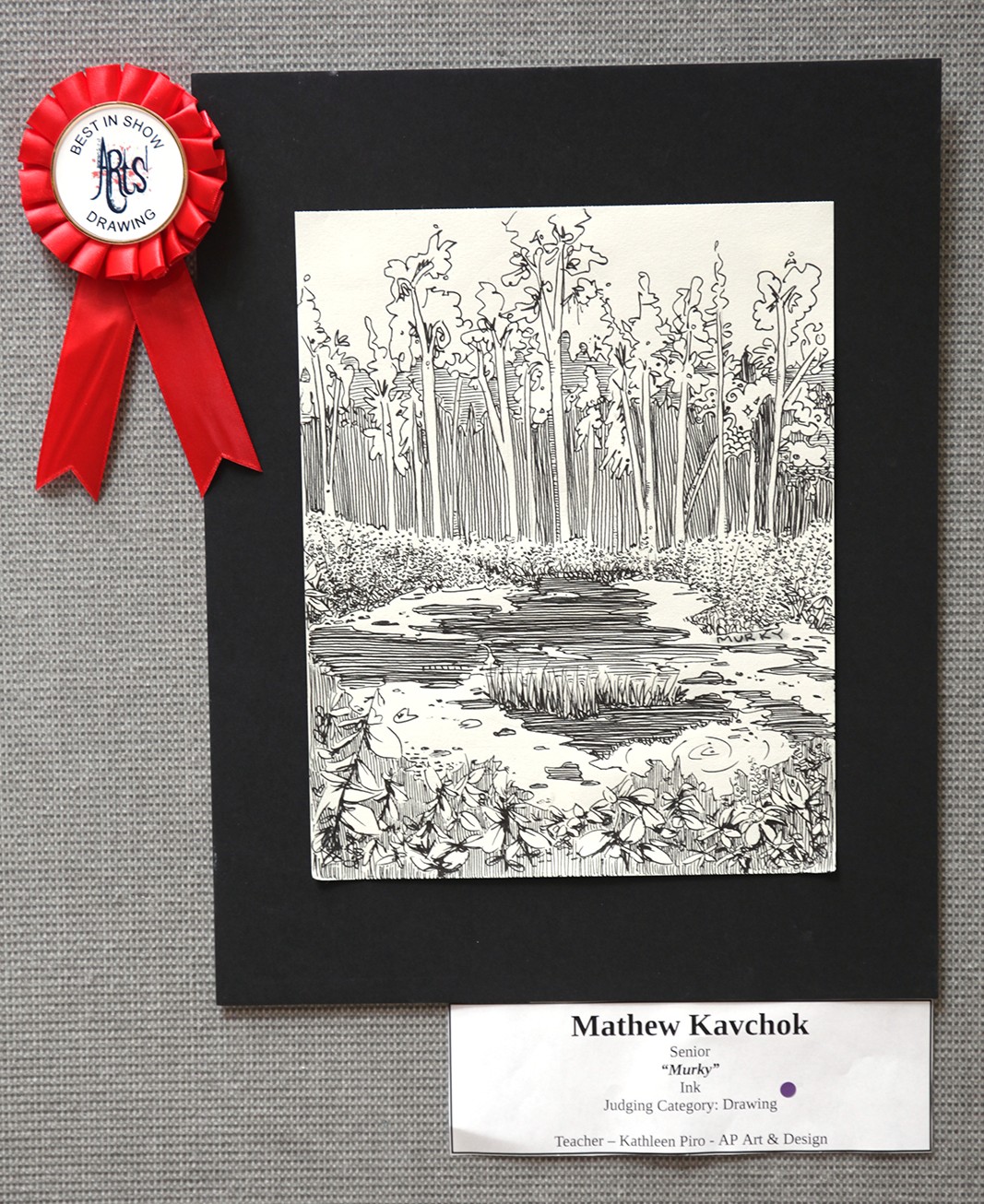 A black mat frames a detailed ink drawing of a serene forest stream in the foreground, with a red "Best in Show" ribbon pinned to the upper left corner and a label identifying the artist and artwork below.