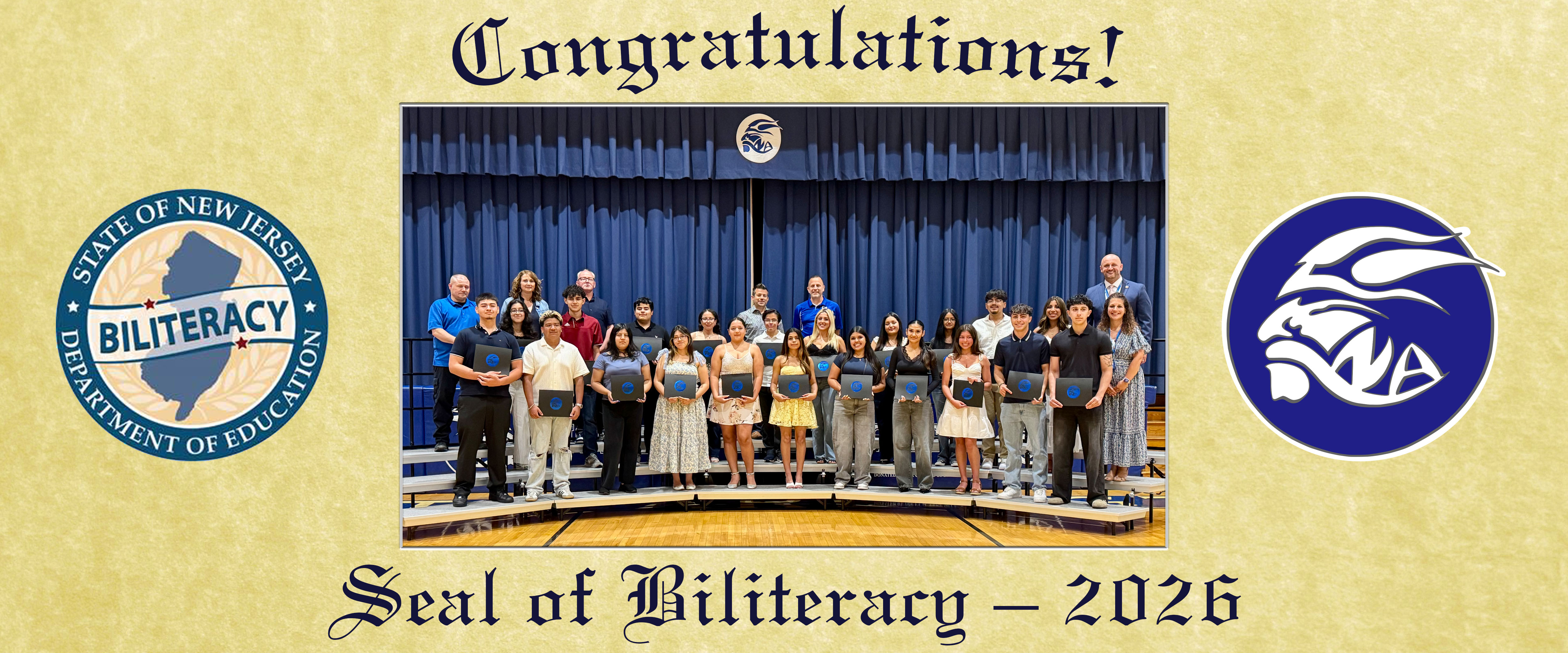 A group of students and adults stand on risers in front of a blue curtain, holding certificates, with the State of New Jersey Seal of Biliteracy and a school logo on either side.
