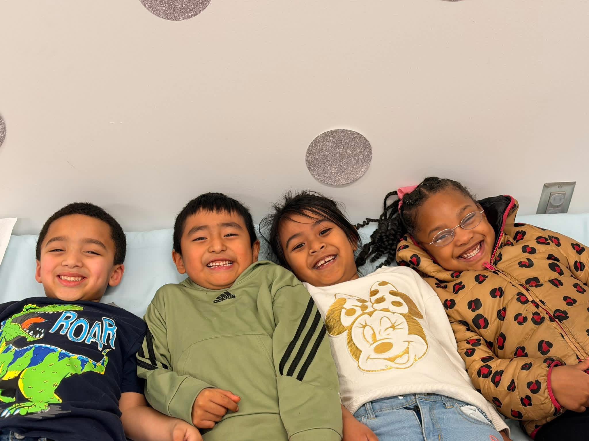 Four students smile as they lay on the ground.