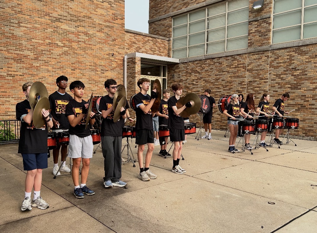 Drum line playing in front of school
