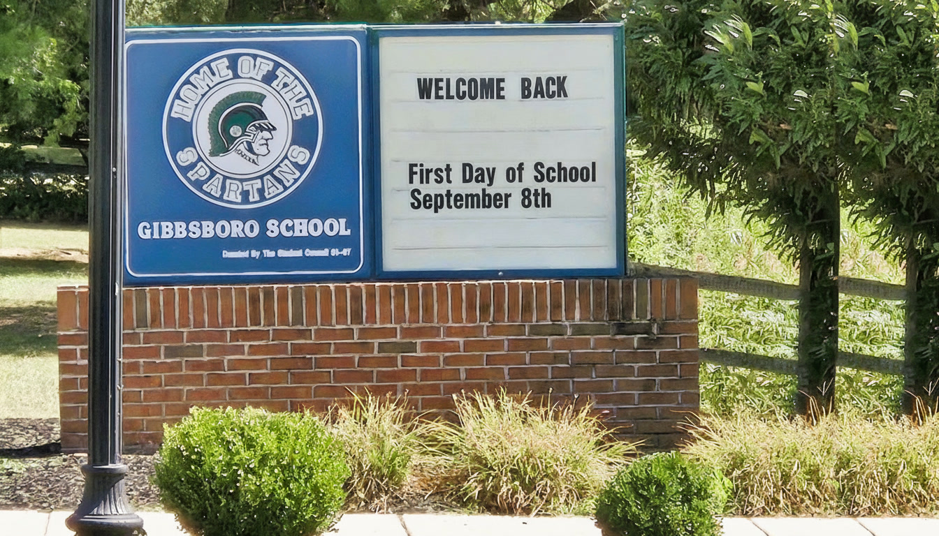 A sign reading "Welcome Back!" "First Day of School September 8th"