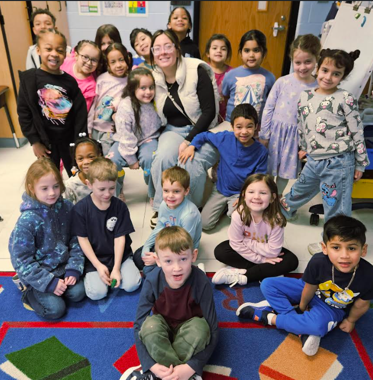 Students gather around a teacher.