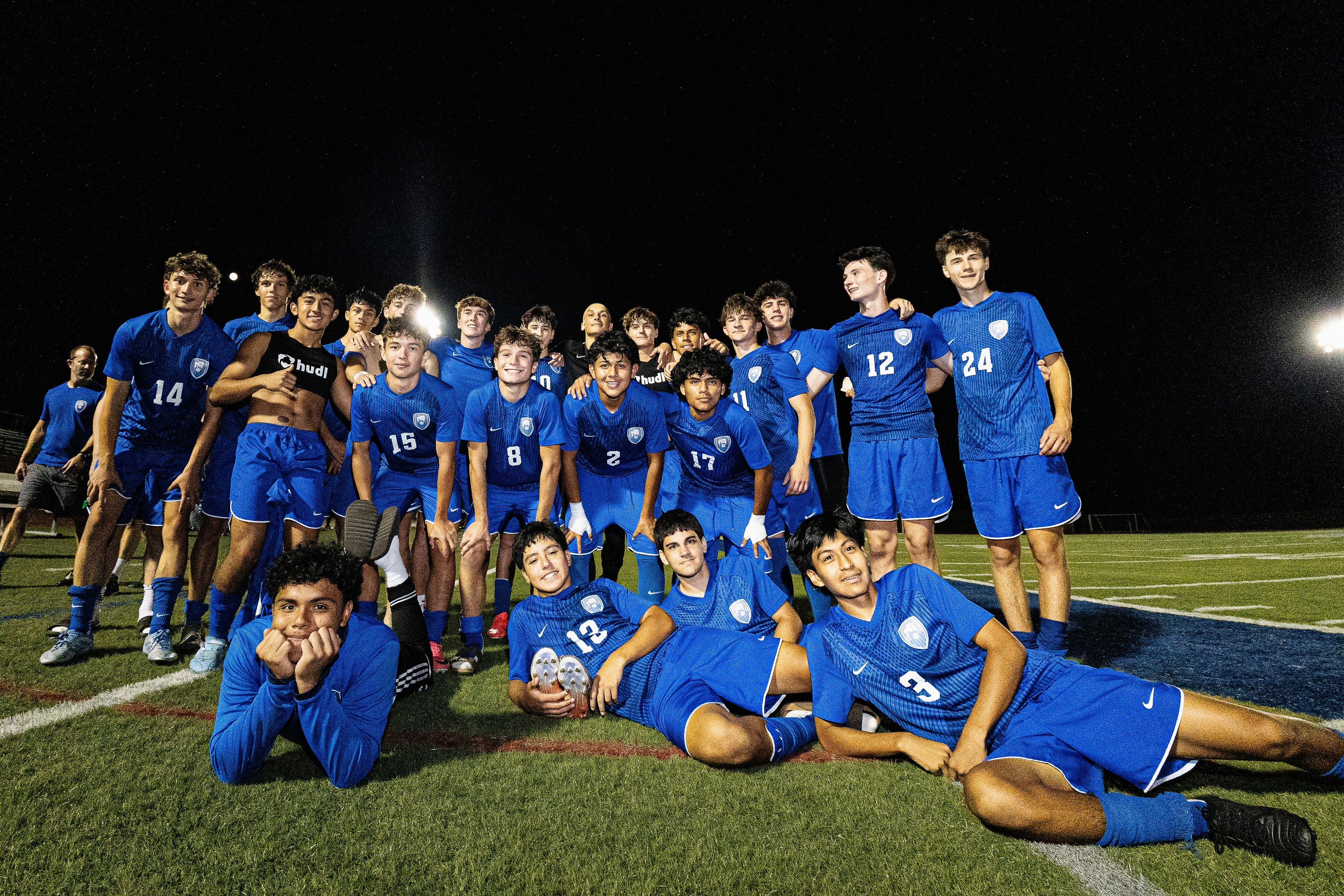 Members of the soccer team on the field during a night game