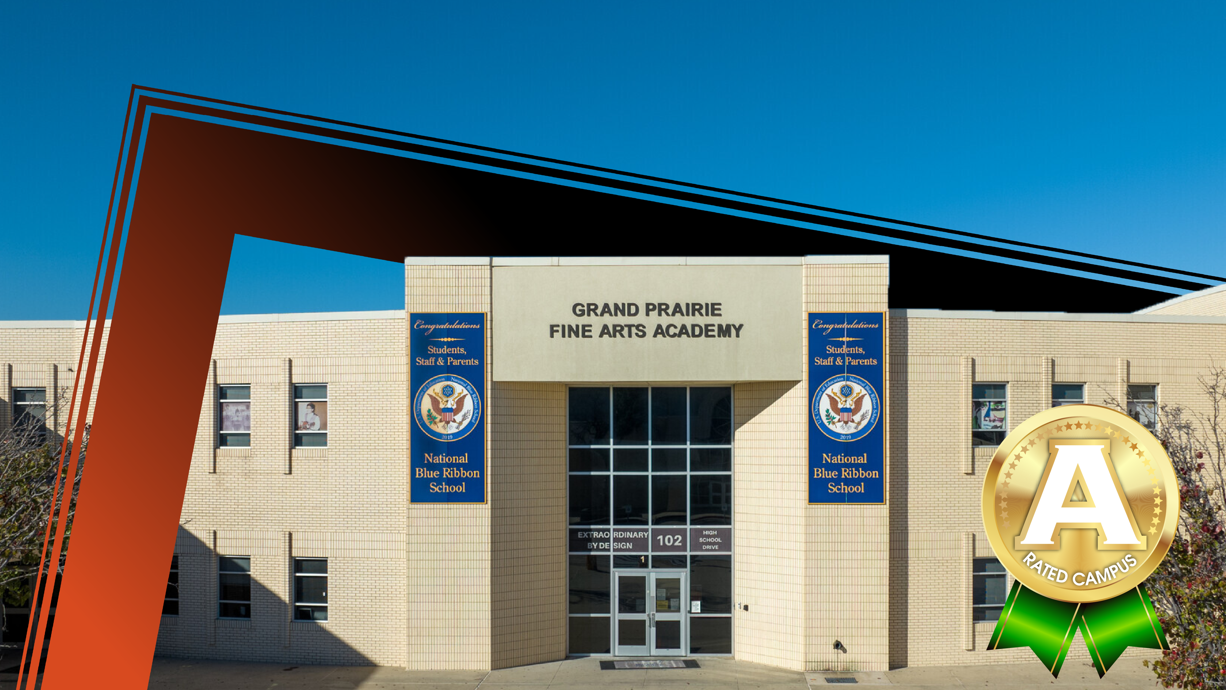 A modern school building with an orange architectural element in the foreground stands against a clear blue sky.