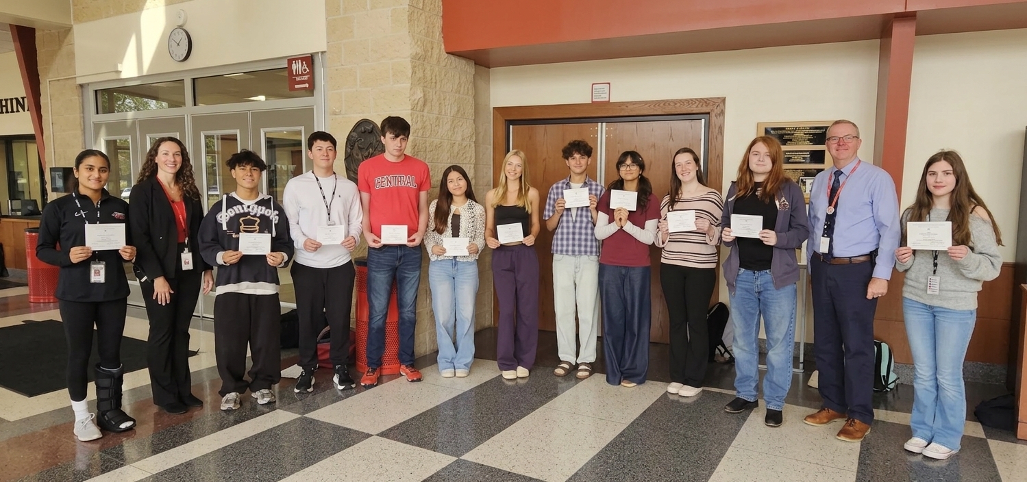 photo of group of high school students holding white recognition cards