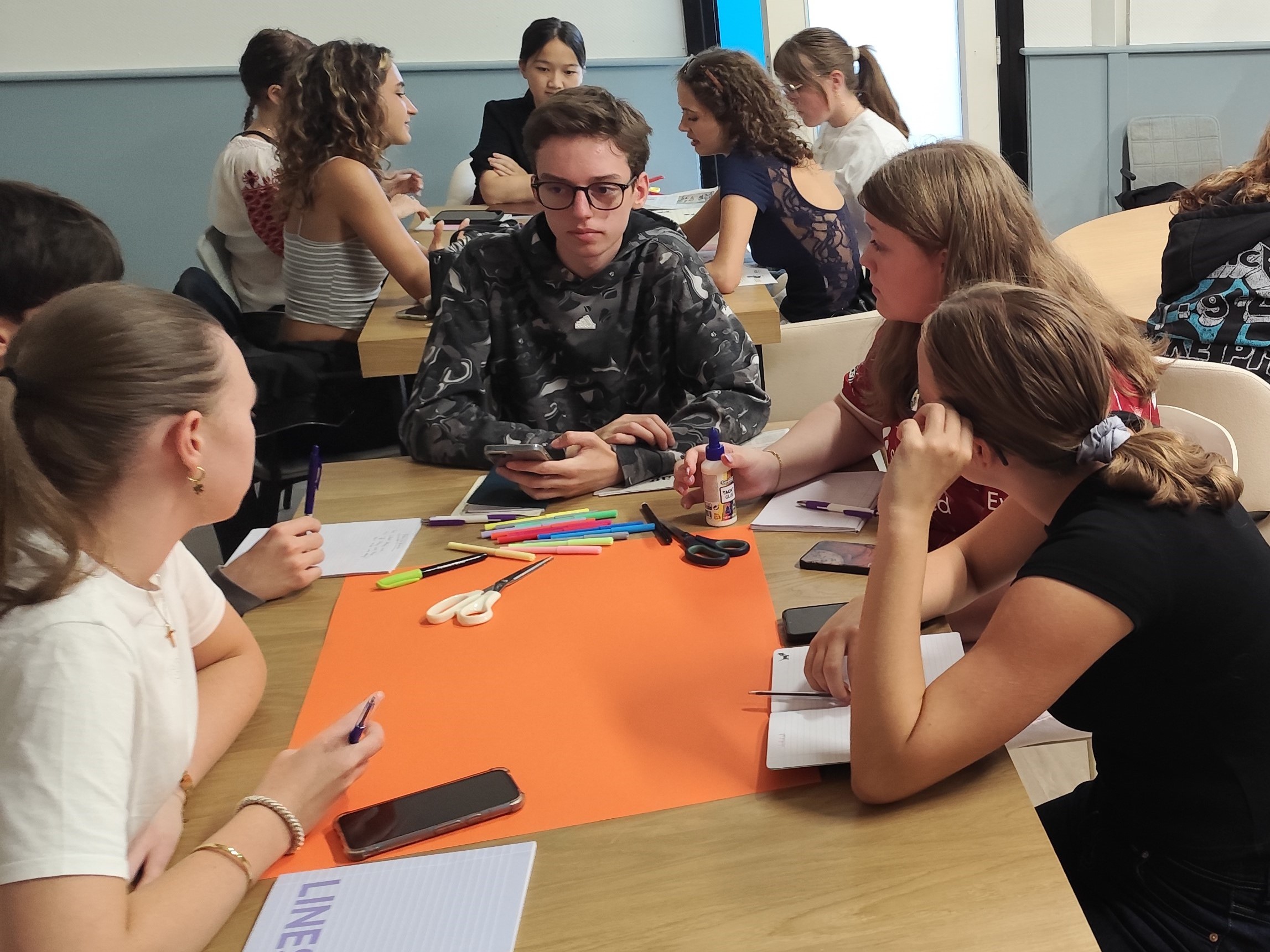 Students collaborating on a poster at a workshop table