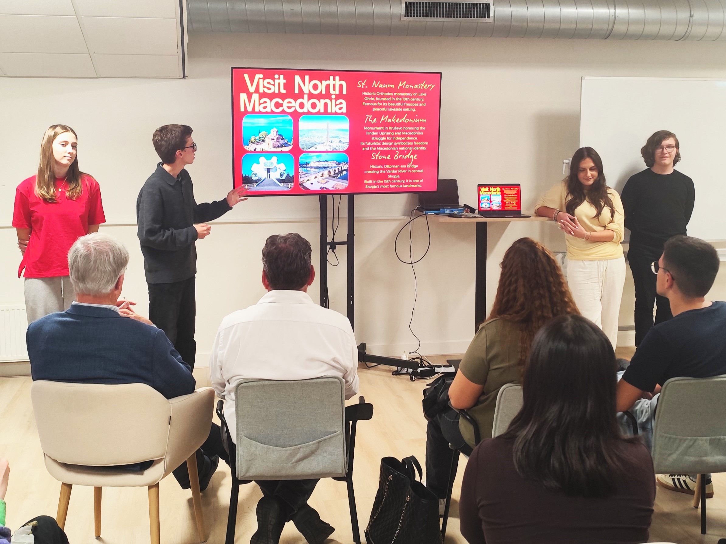 Students presenting a Visit North Macedonia slideshow to an audience