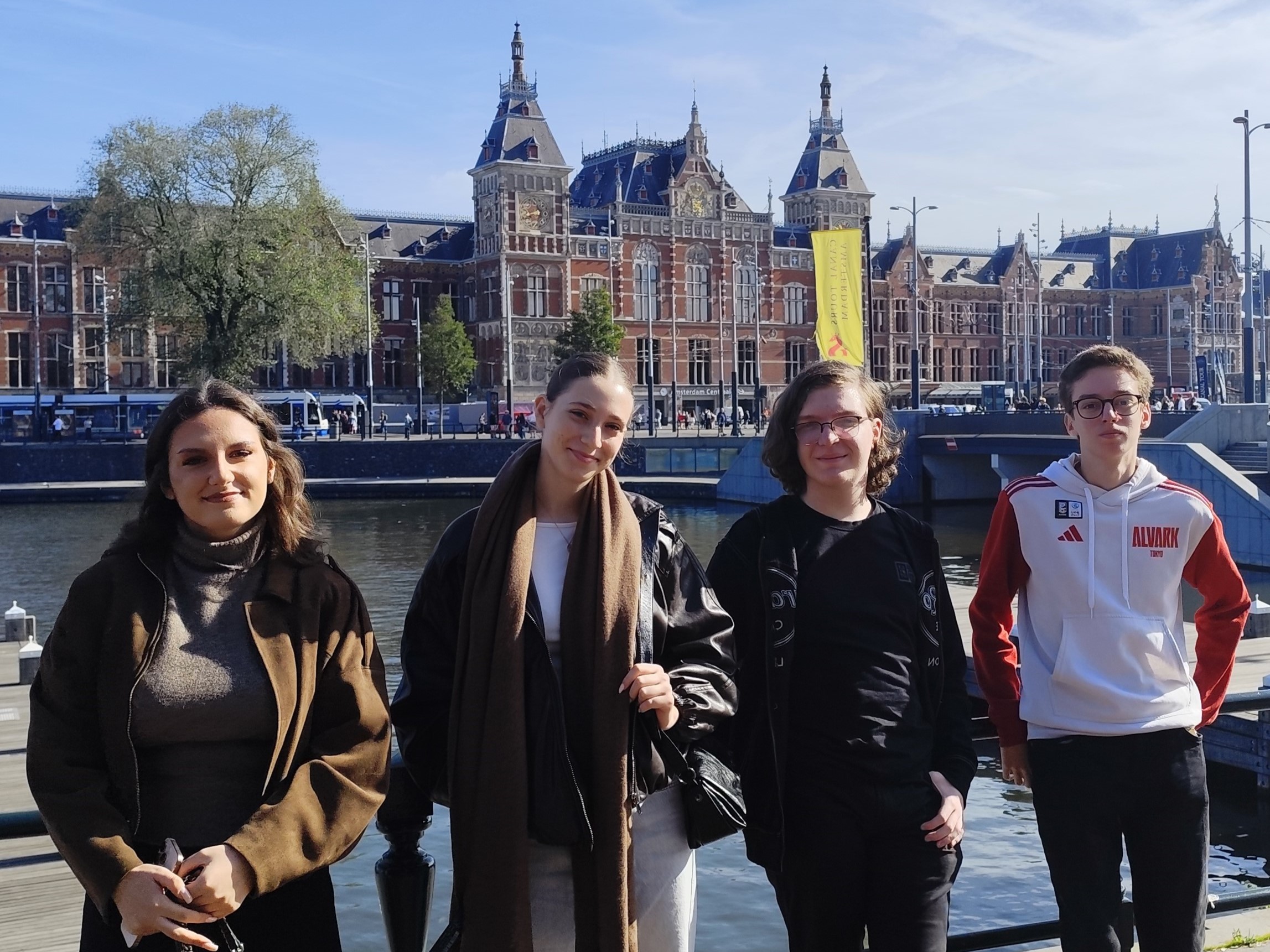 Four NOVA students by a canal in front of a historic station building