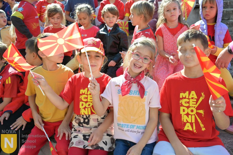 Young students waving North Macedonian flags at the Parade of Nations