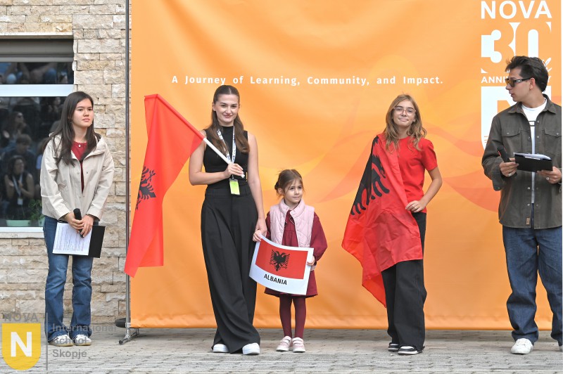 Family holding Albanian flags at the Parade of Nations