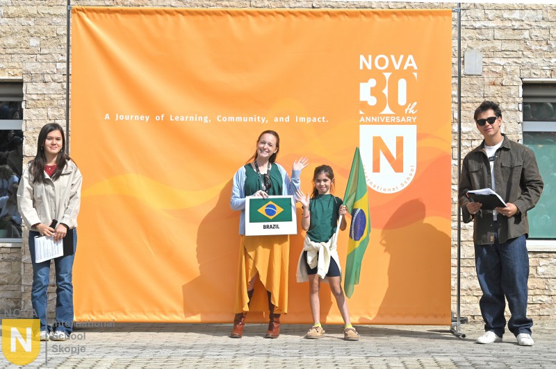 Parent and child holding the Brazilian flag and sign at the Parade of Nations