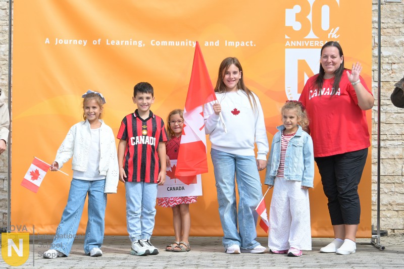 Family holding Canadian flags at the Parade of Nations