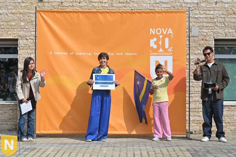 Family holding their flag and country sign at the Parade of Nations