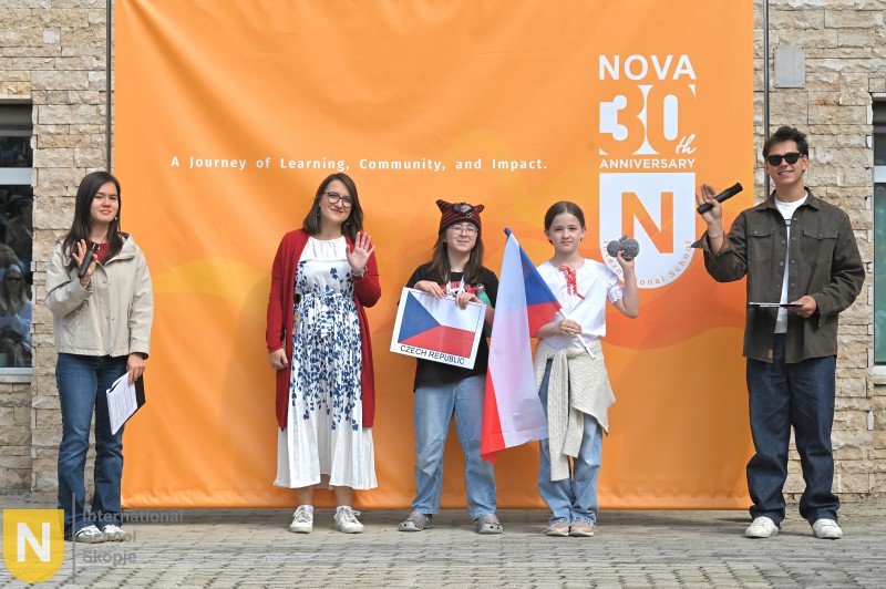 Family holding their flag and country sign at the Parade of Nations
