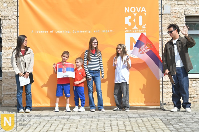 Family holding the Serbian flag at the Parade of Nations