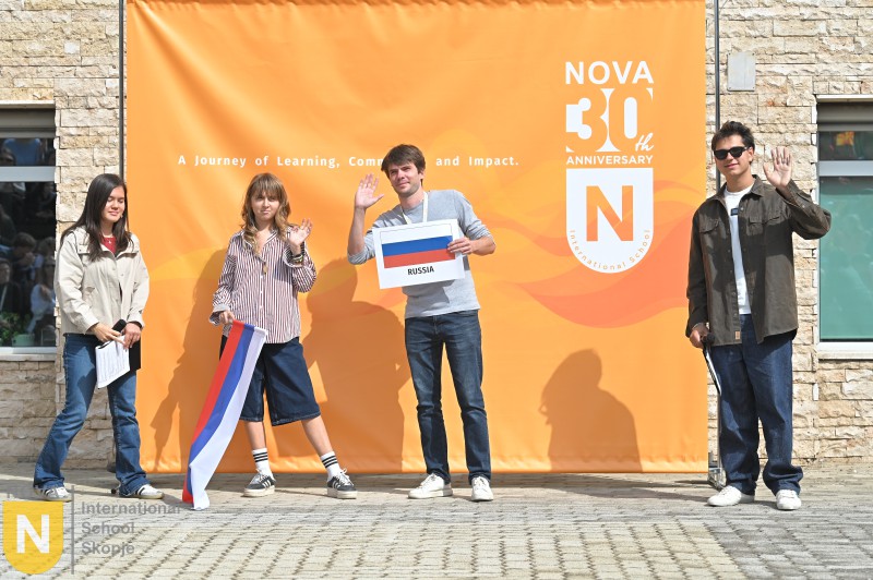 Students holding their country flag and sign at the Parade of Nations