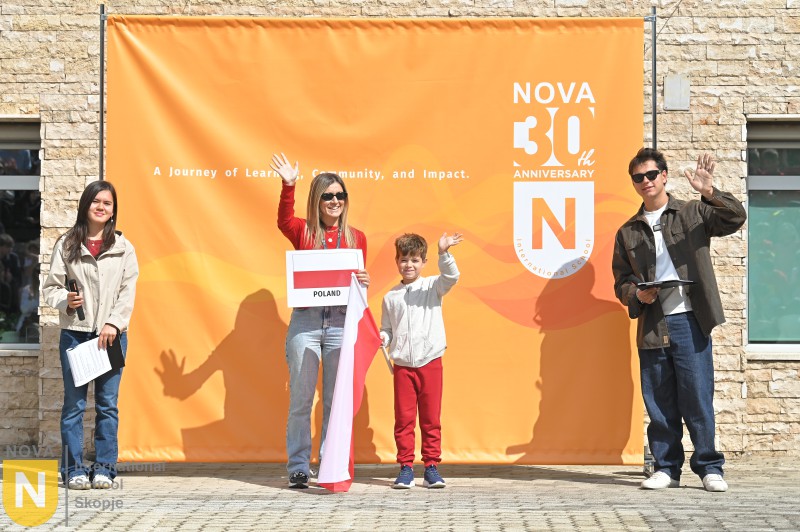 Family holding a red and white flag at the Parade of Nations