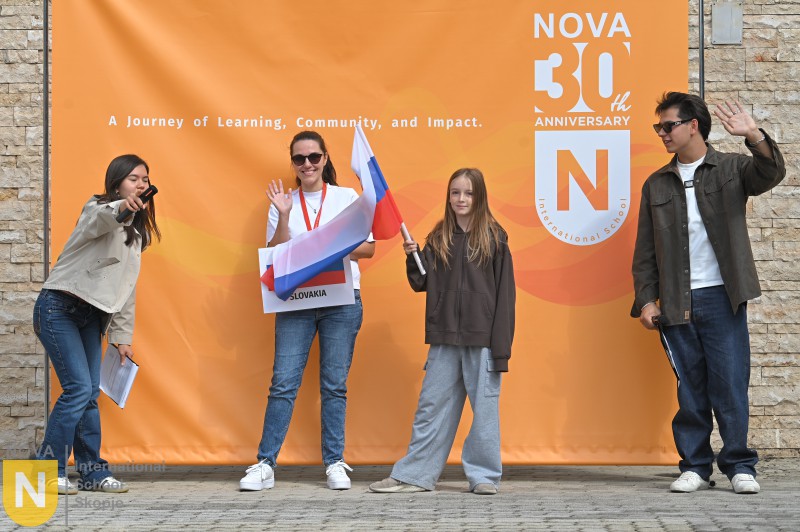 Students holding a white, blue and red flag at the Parade of Nations