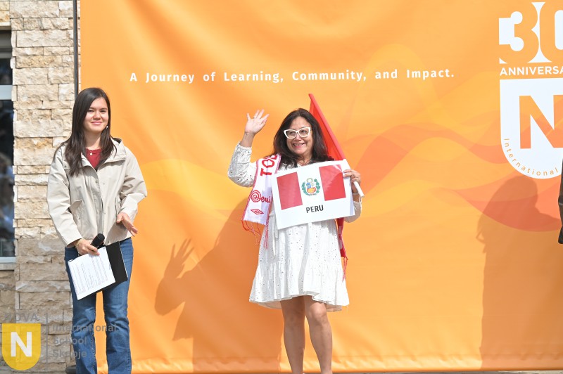 Parent holding the Peruvian flag at the Parade of Nations