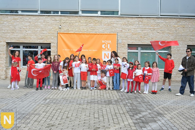 Class of young students waving Turkish flags in the schoolyard