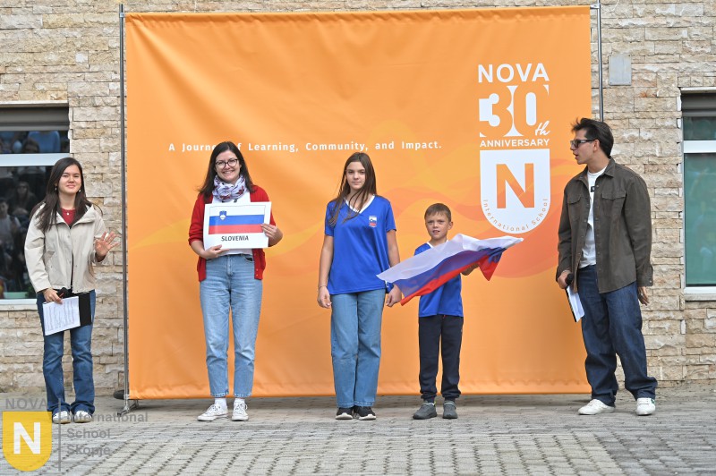 Family holding the Slovenian flag at the Parade of Nations