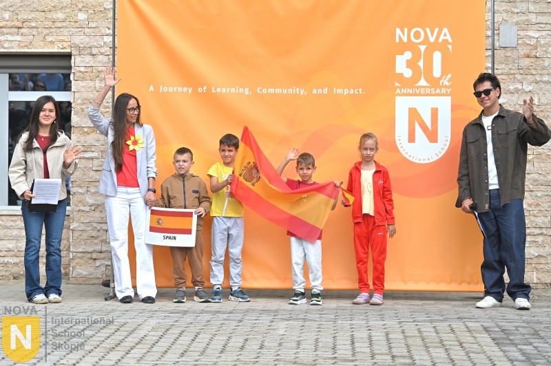 Family with children holding the Spanish flag at the Parade of Nations