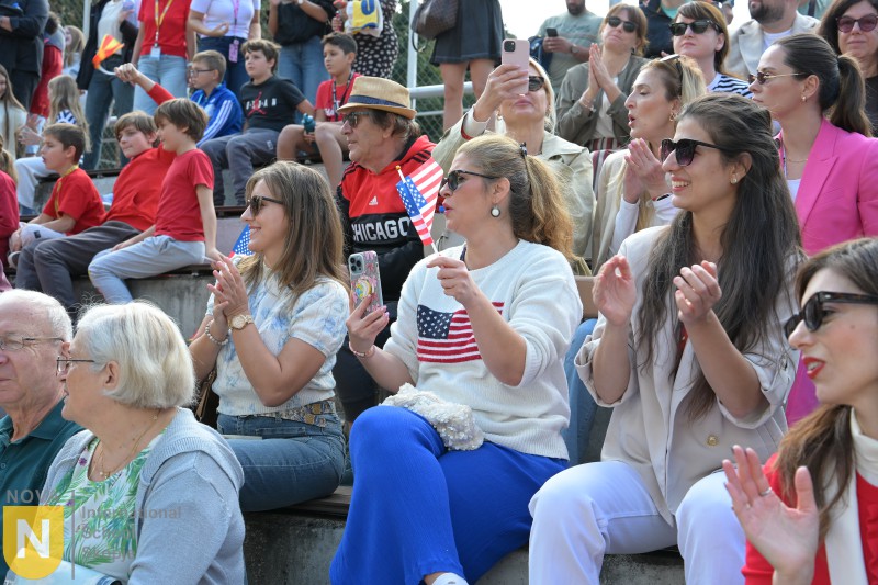Parents clapping and waving flags at the Parade of Nations