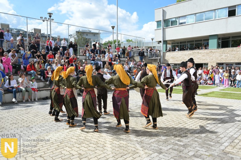 Folk dancers in traditional costume performing in the schoolyard