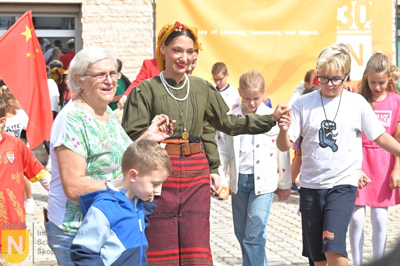 Parents in traditional dress with students at the Parade of Nations