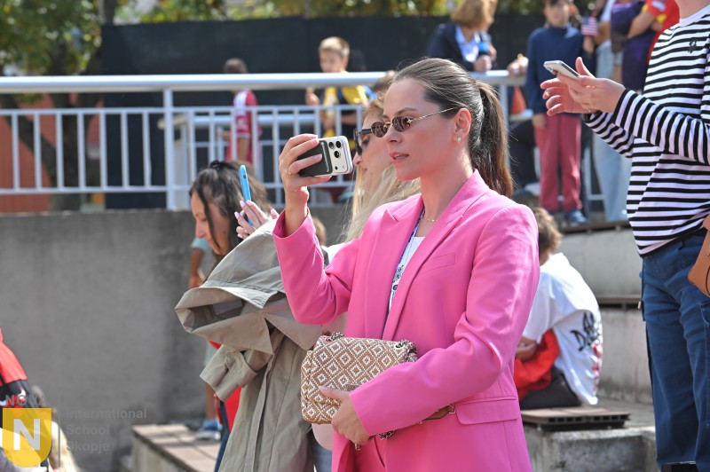 Parent taking photos of the performance at the Parade of Nations
