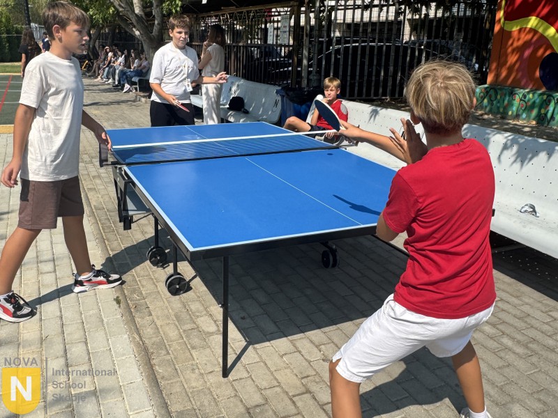 Two students playing table tennis in the schoolyard
