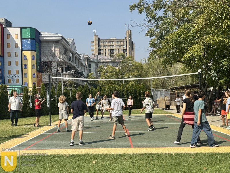 Students competing in outdoor volleyball on a sunny day
