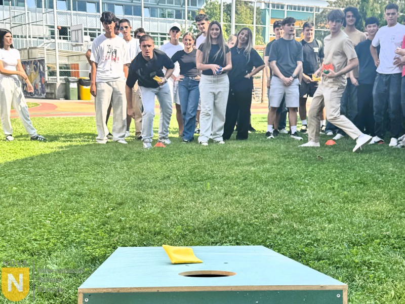Students cheering as a classmate throws in a cornhole game