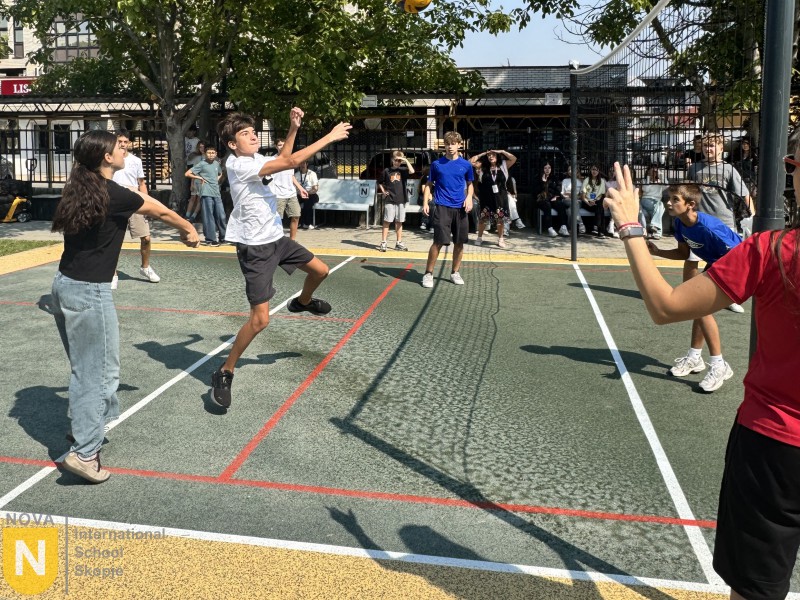 Students playing volleyball on the outdoor court during House activities