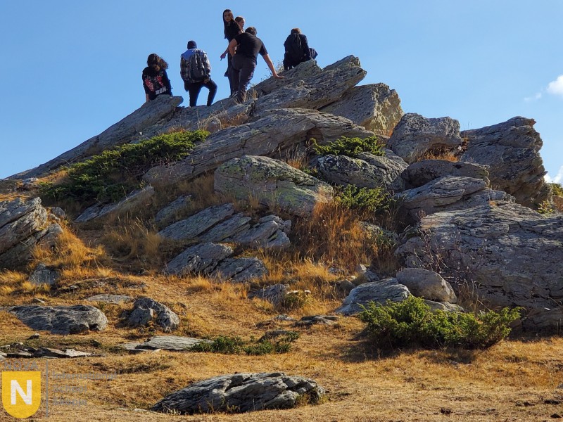 Students climbing on large rocks at a mountaintop