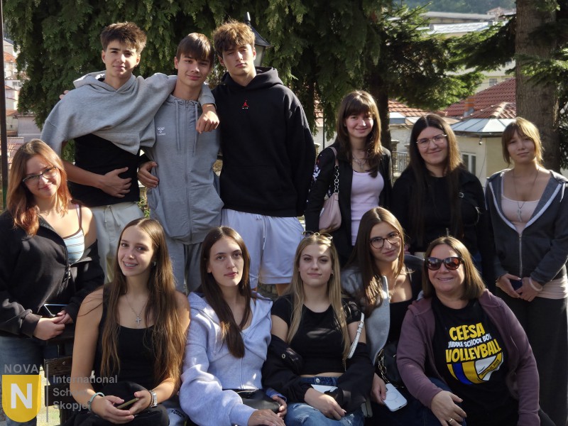 Group of smiling secondary students posing together on a trip