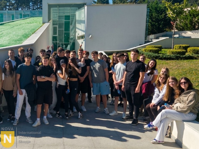 Large group of students posing outside a modern building