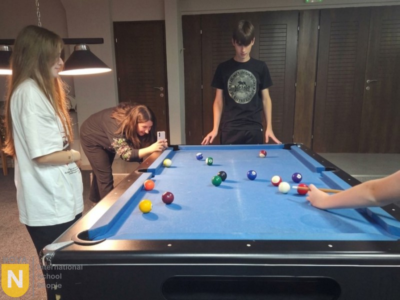 Students playing pool during free time on the trip