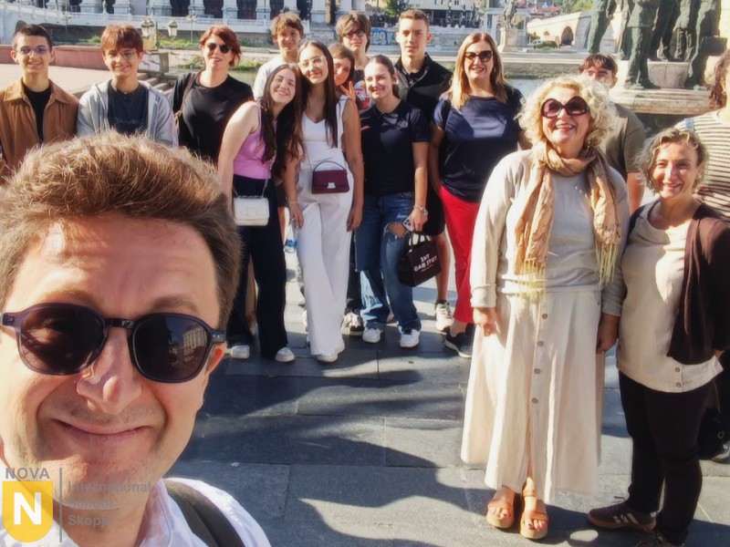 Teacher taking a selfie with a group of students on a trip