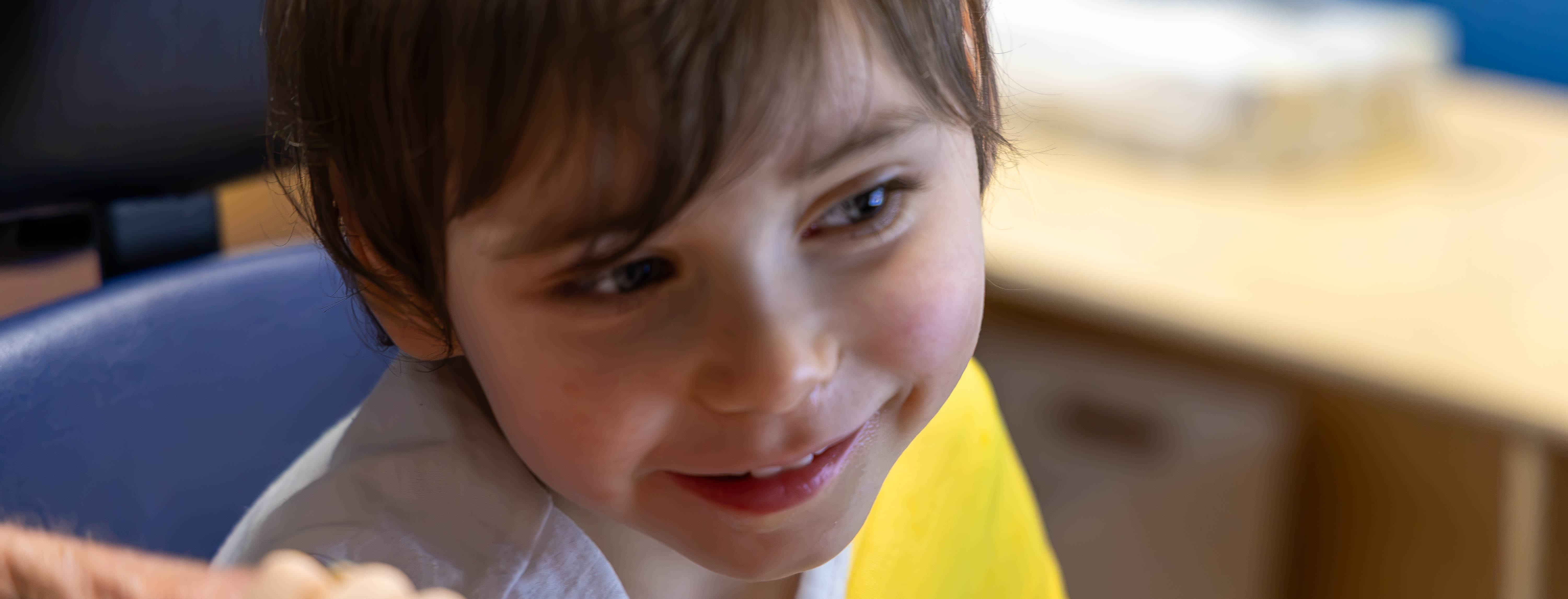 A young student smiles at toys.