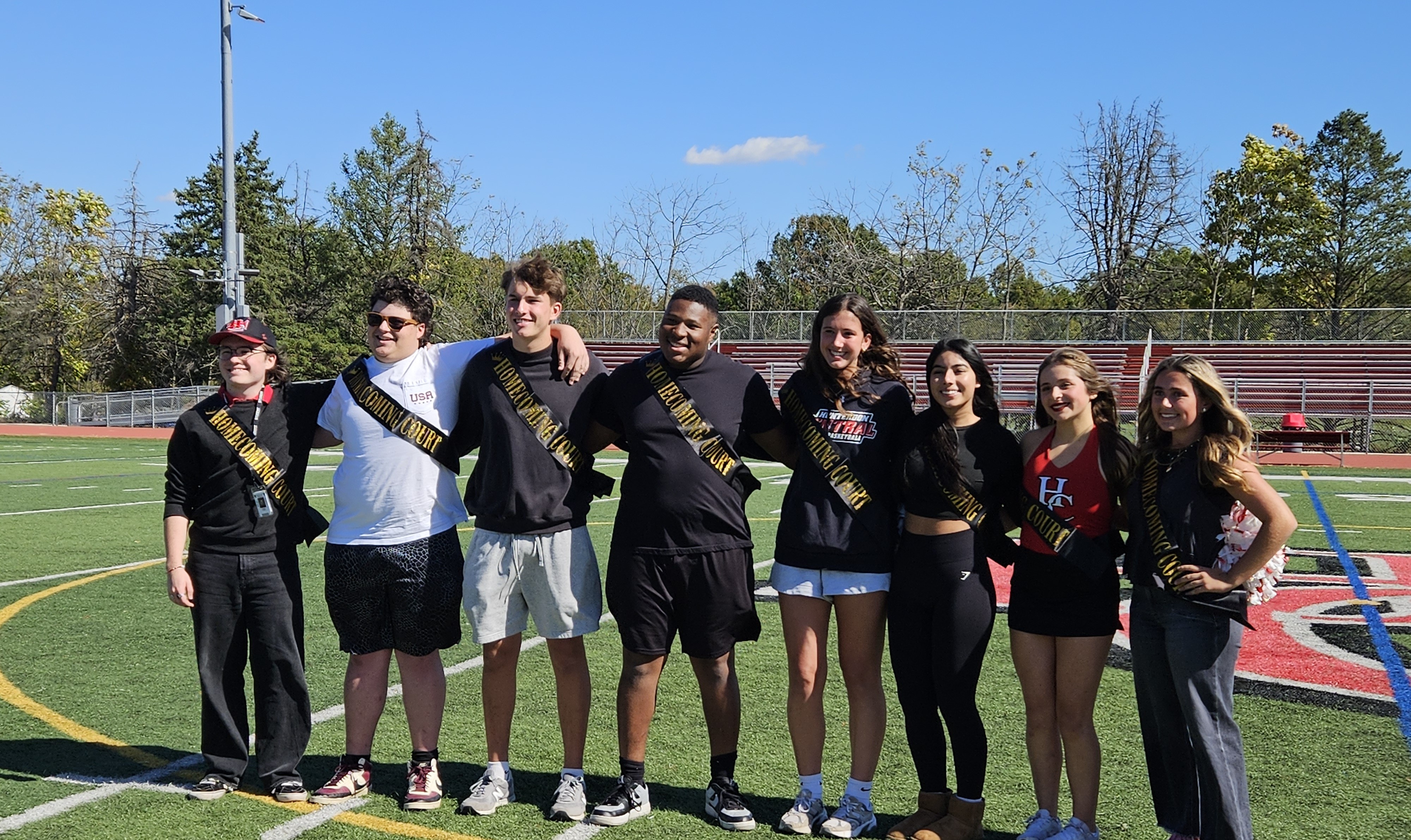 photo of 8 students wearing homecoming court sashes.