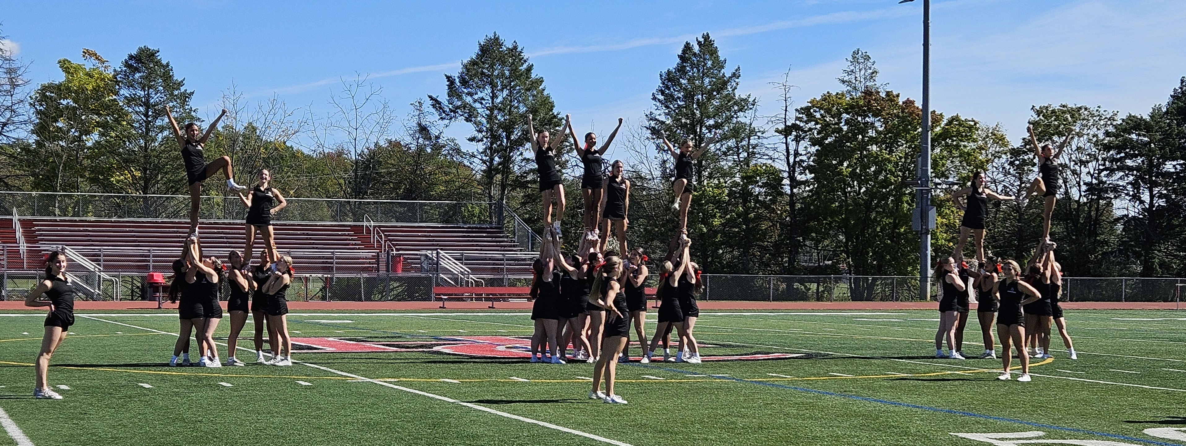 cheerleaders in black and red uniforms in pyramid formations